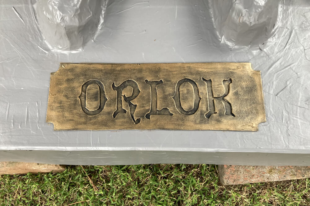 Paper maché Count Orlok statue - fake metal plate that says ORLOK, attached to the base of the statue