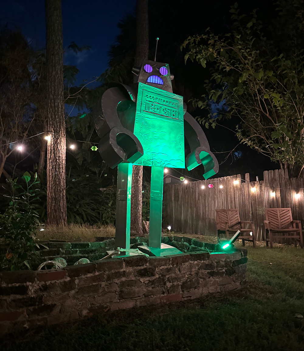 The giant robot standing in our yard, with a green spotlight on it