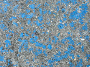 Scraped blue paint revealing gray cement