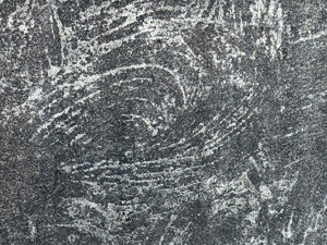 Curved scaped lines on dark gray concrete