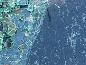 Shattered car window with tons of tiny cracks and pieces falling off