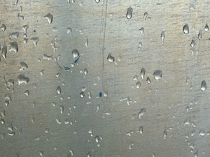 Rain drops on a brushed metal surface