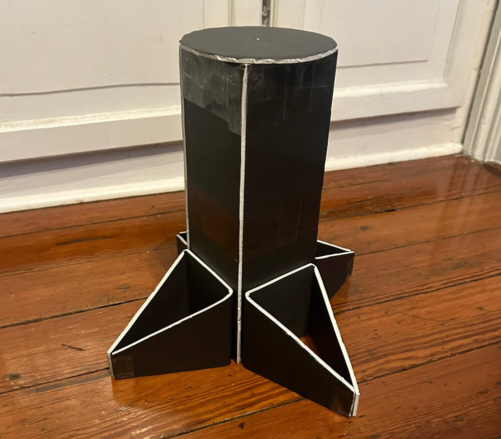 A stand for the mask, made of black foam board