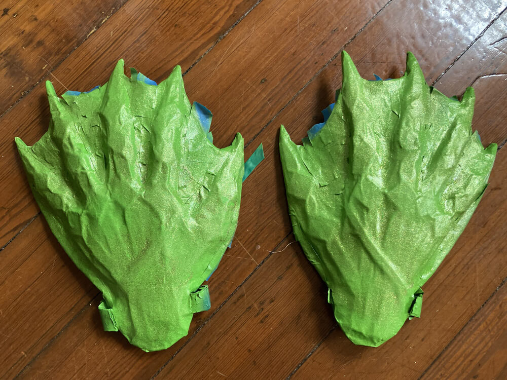 Hands painted light green, painter's tape still in place