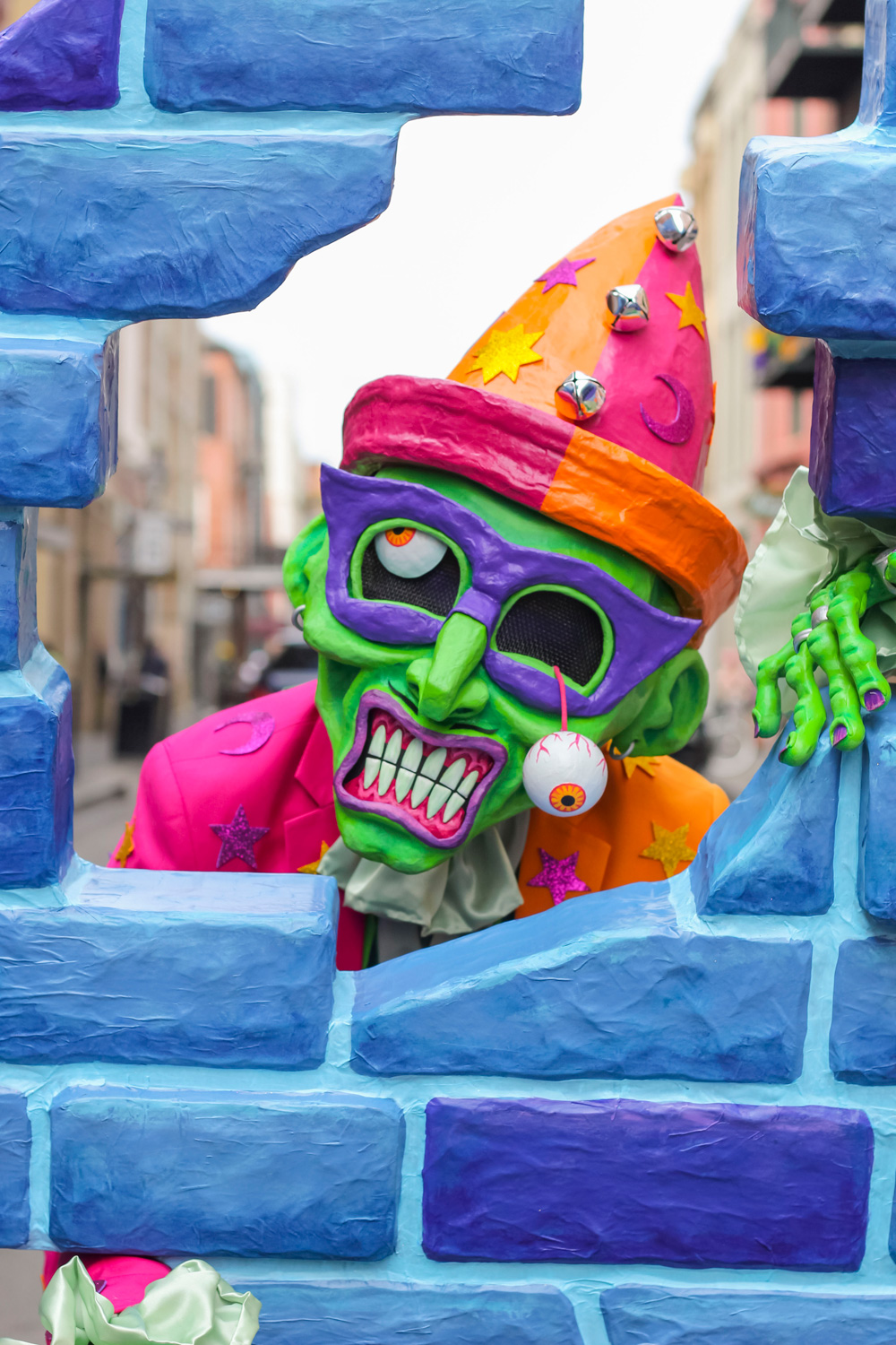 Close up of me in my Fortunato costume; it's my head in the big green zombie mask peering through the large hole at the top of the fake brick wall.