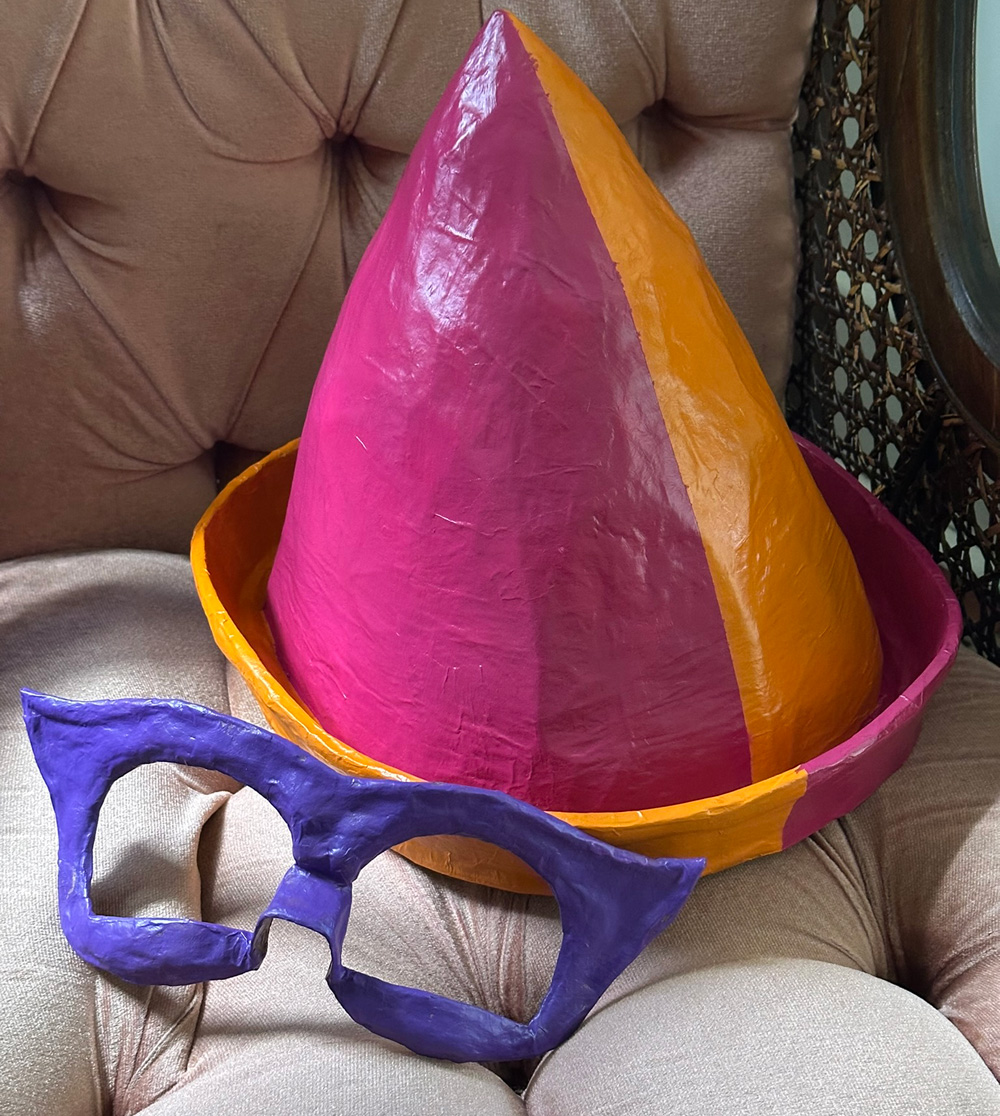 The eye mask and hat sitting separately, painted