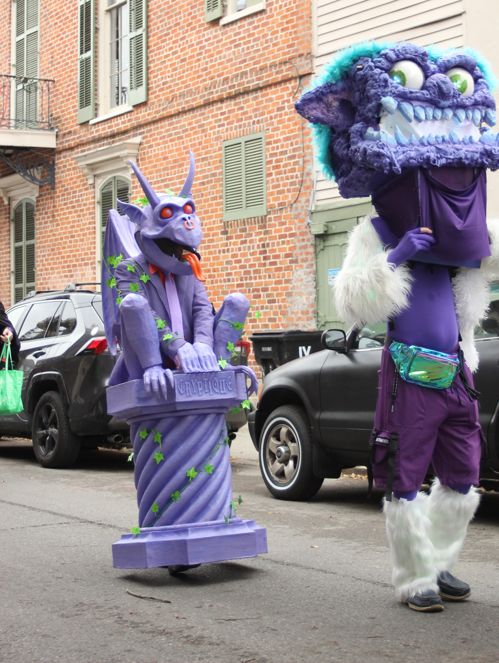 My Mardi Gras gargoyle costume; a purple gargoyle sitting on a purple column, walking down the street in a small parade.