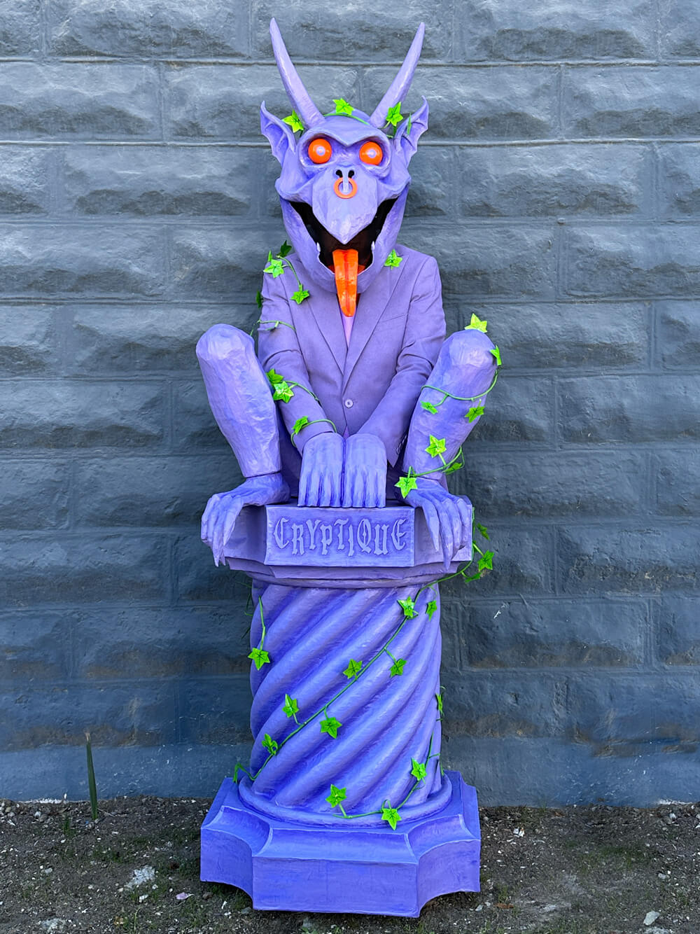 Wider shot of the finished gargoyle costume; it's all purple, with a fake stone column hiding my legs and fake legs crouched on top of the column.