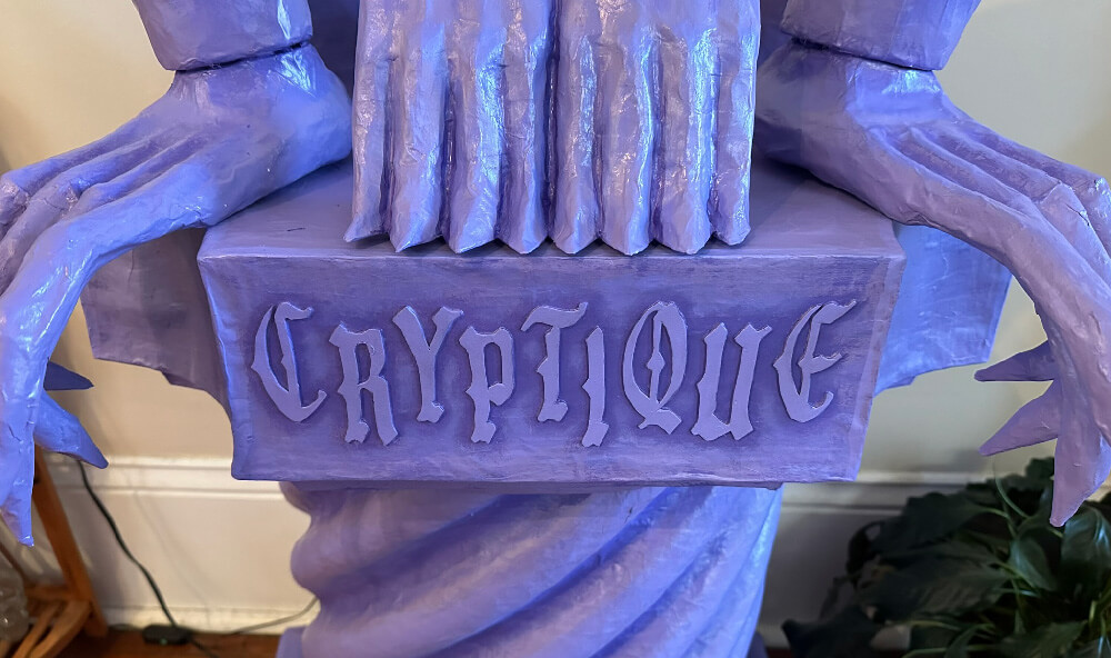 Close up of the painted hands and feet and the word Cryptique.