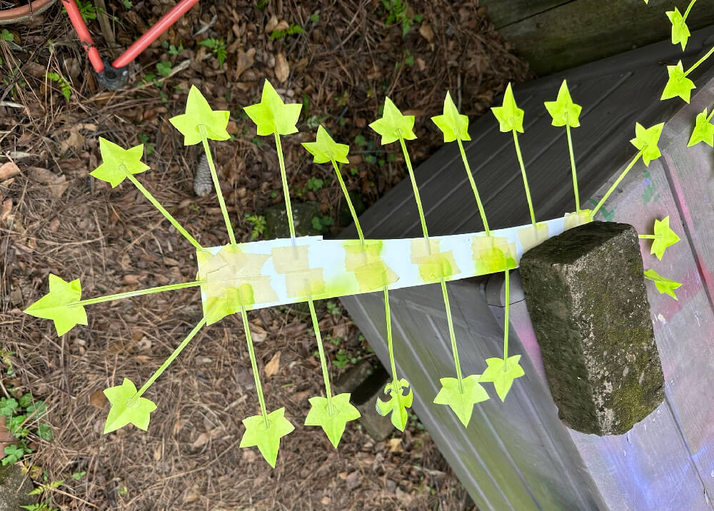 Lots of fake ivy leaves and stems taped to a strip of foam and spray painted light green.
