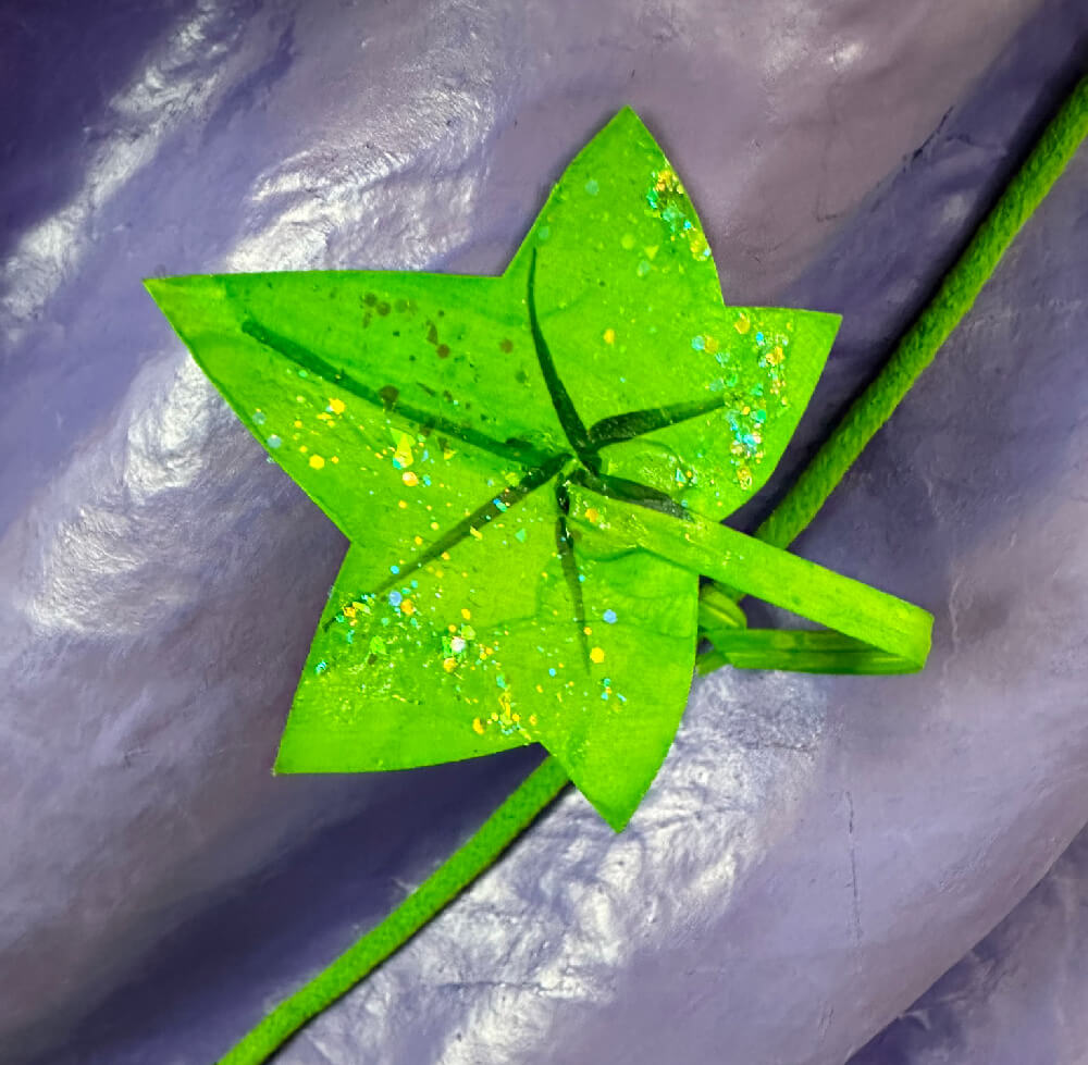 Close up of a fake ivy leave; it's bright green with green glitter.