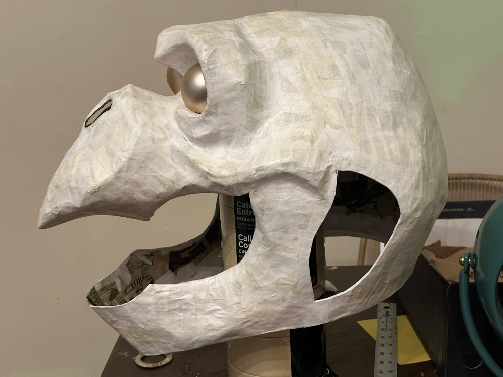 The mask in profile; the mouth area has been cut out, as have the holes behind the mouth
