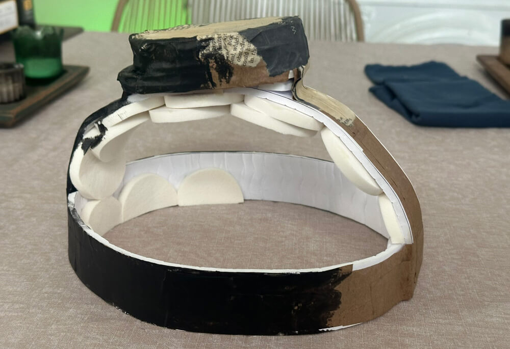 The headpiece structure again, now painted black and with a small block of foam attached to the top.