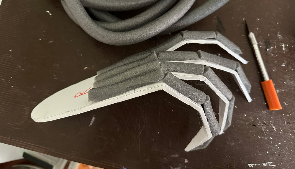 The gargoyle feet now have lengths of gray foam tubes on them, running along the backs of the feet and toes.
