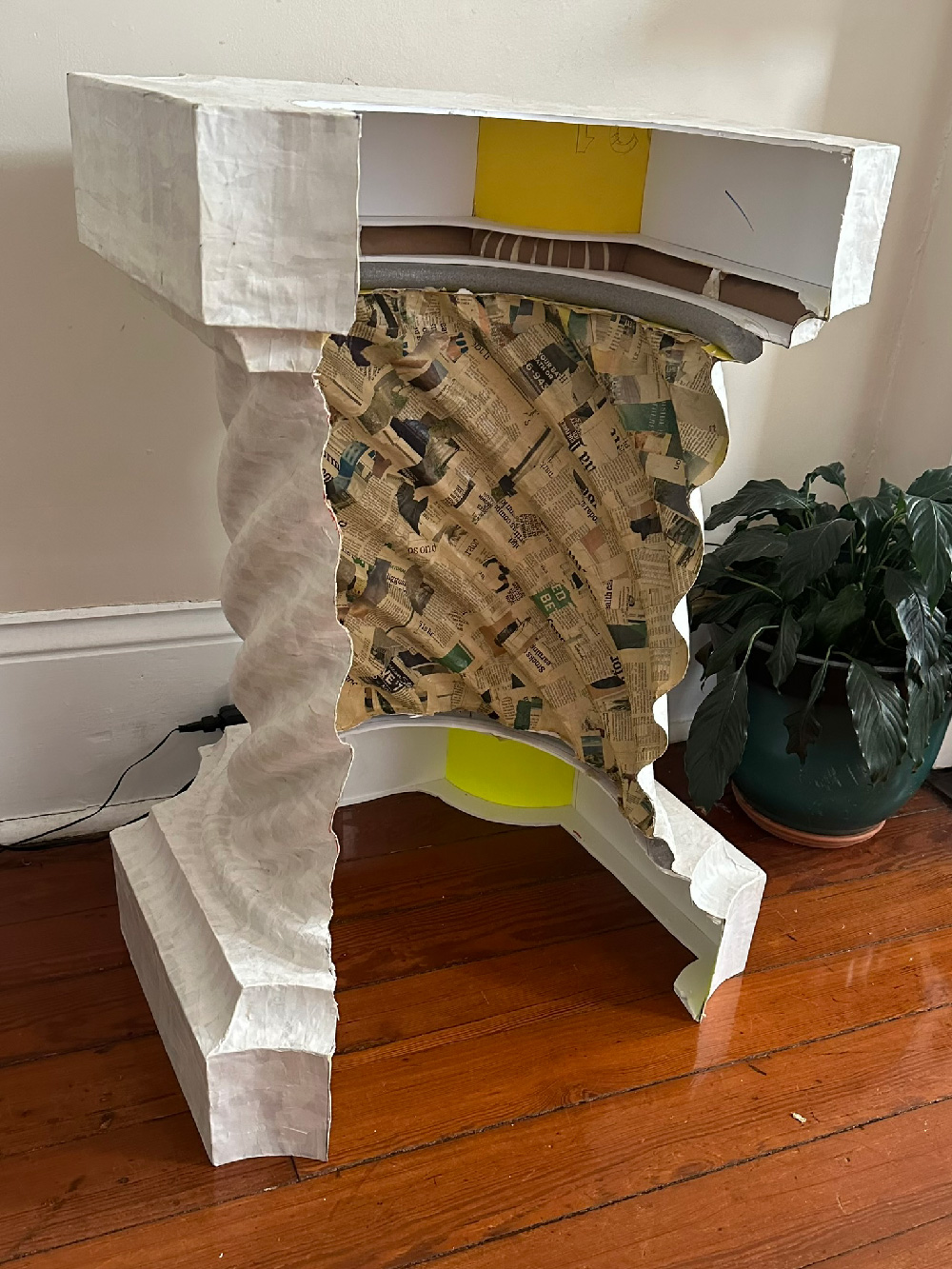 Paper mache stone column with the whole back area cut out, showing the hollow inside area