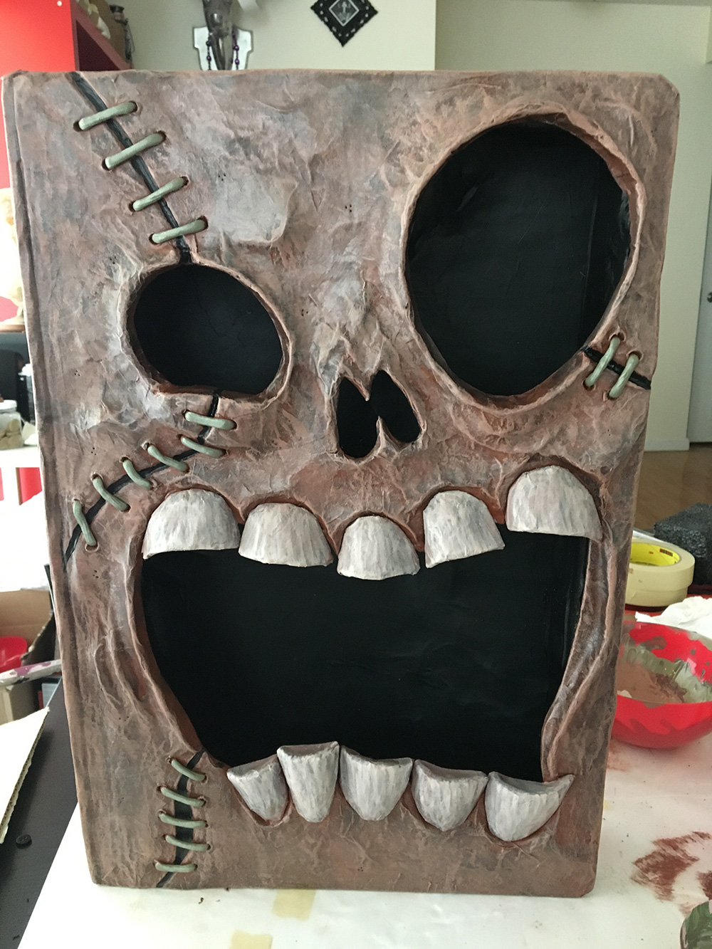 Haunted book sculpture - painting the details with acrylic paint