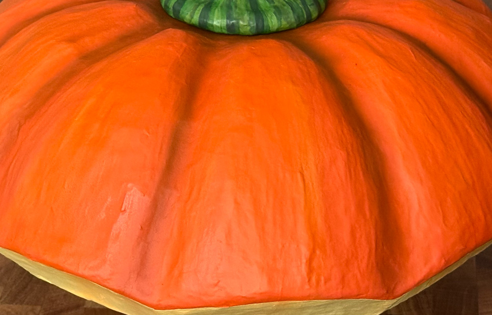 Close up of the relatively smooth surface of the painted pumpkin lid sculpture.