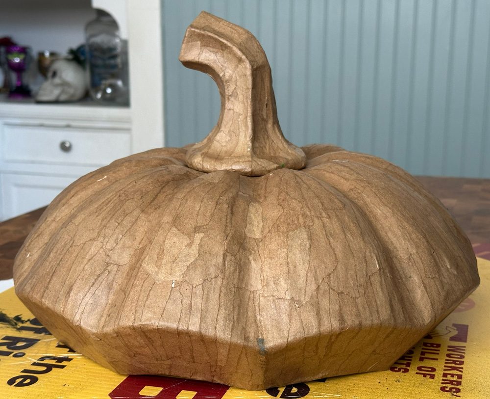 Another view of the pumpkin lid sculpture, unpainted, and viewed from a lower angle so the outer edge is more visible.