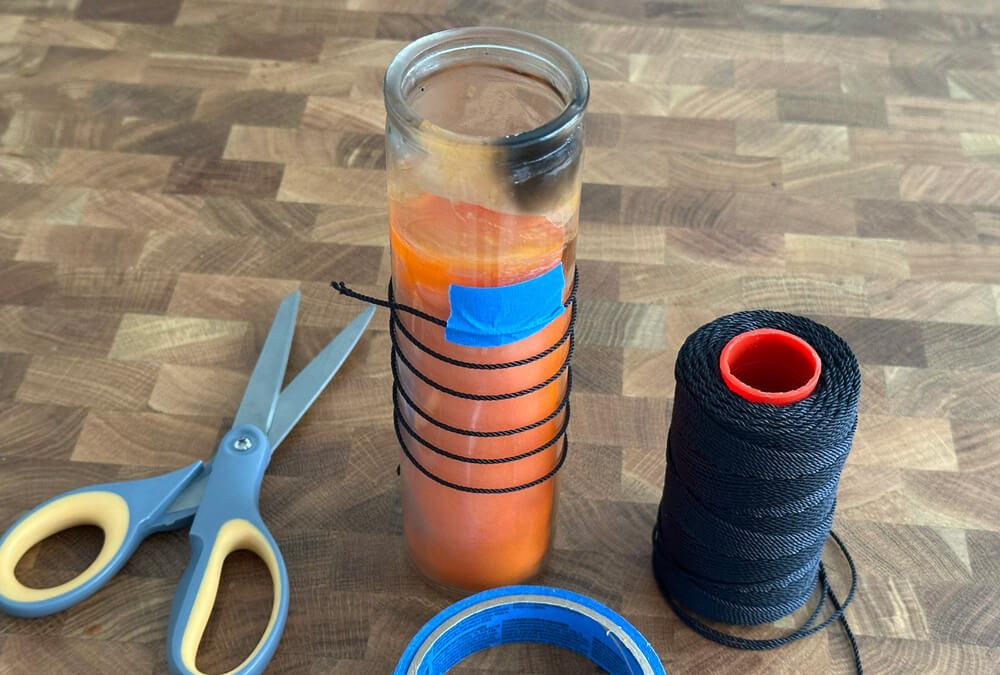 A prayer candle with a string wrapped around it.