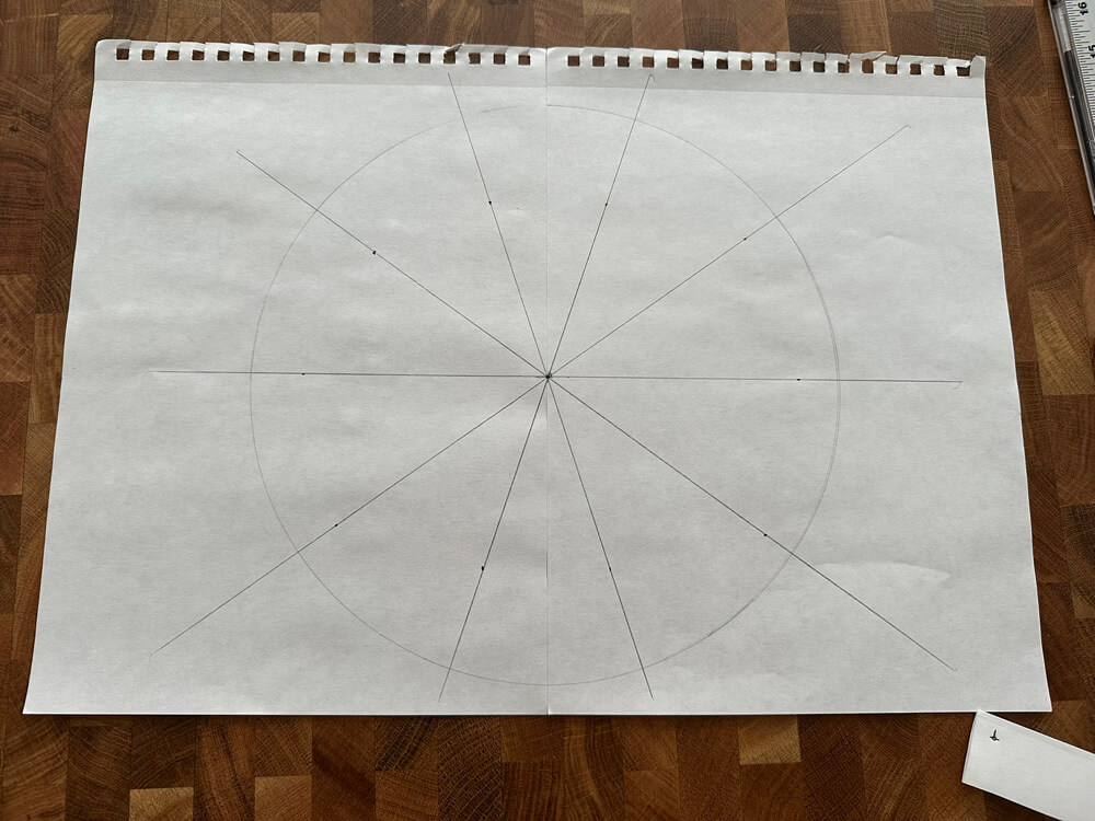 A circle drawn on paper with five lines crossing through it.