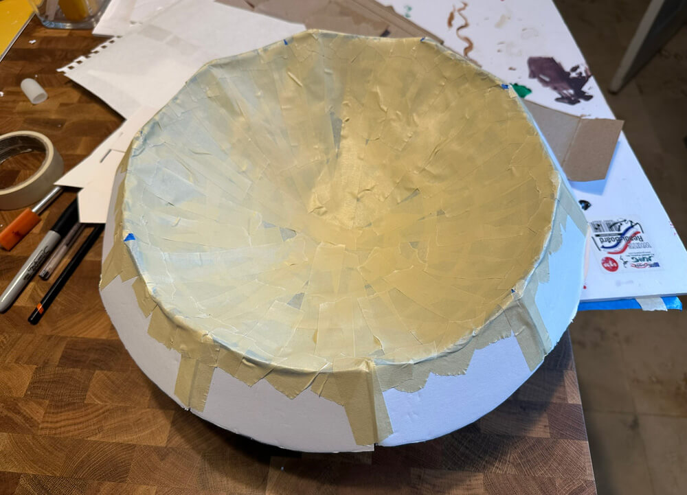 The interior surface is now a bowl shape covered in masking tape.