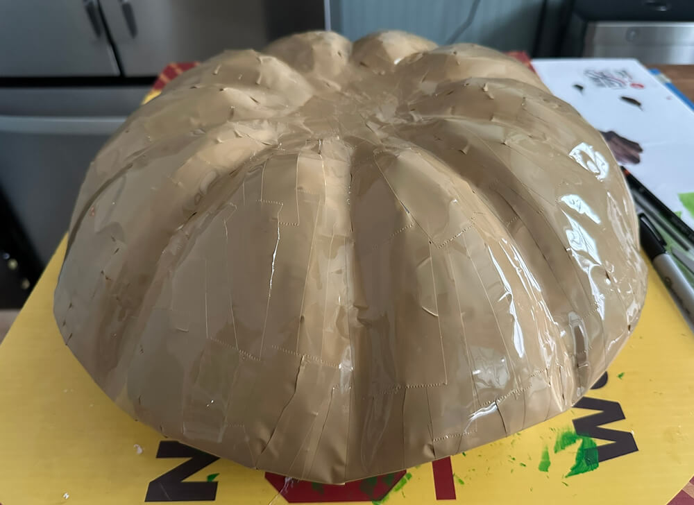 The entire lid is now covered in shiny tan tape.