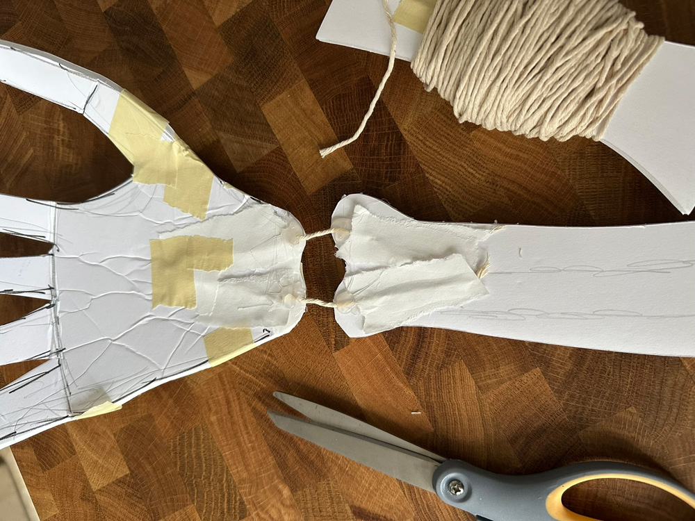 Connecting the hand to the wrist with two pieces of cotton string and hut glue.