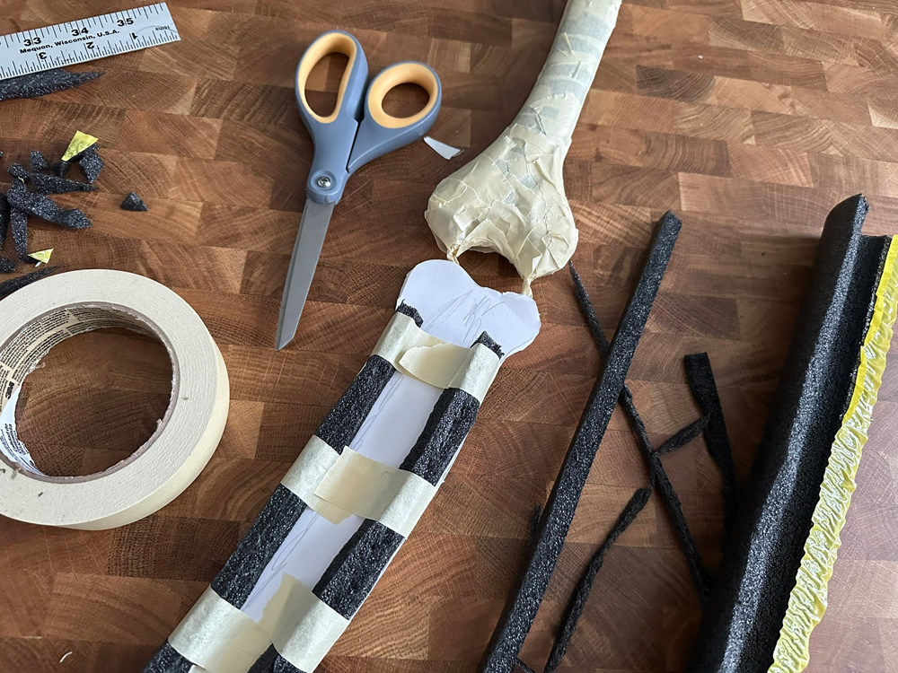 The forearm bones with some long pieces of black foam tapes in place to pad them out.