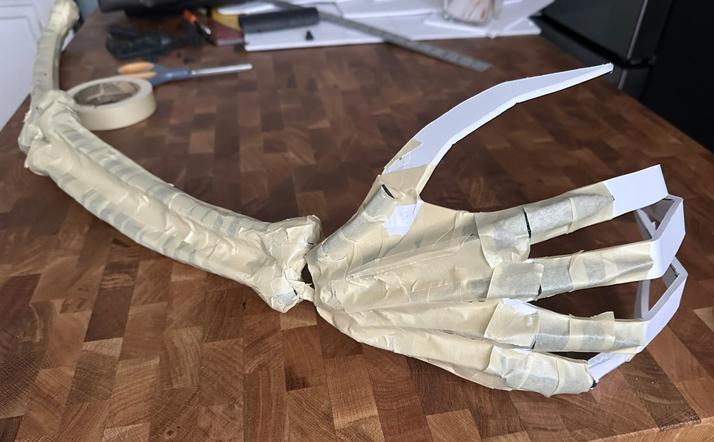 The hand with some long pieces of foam taped onto the back to form bones.