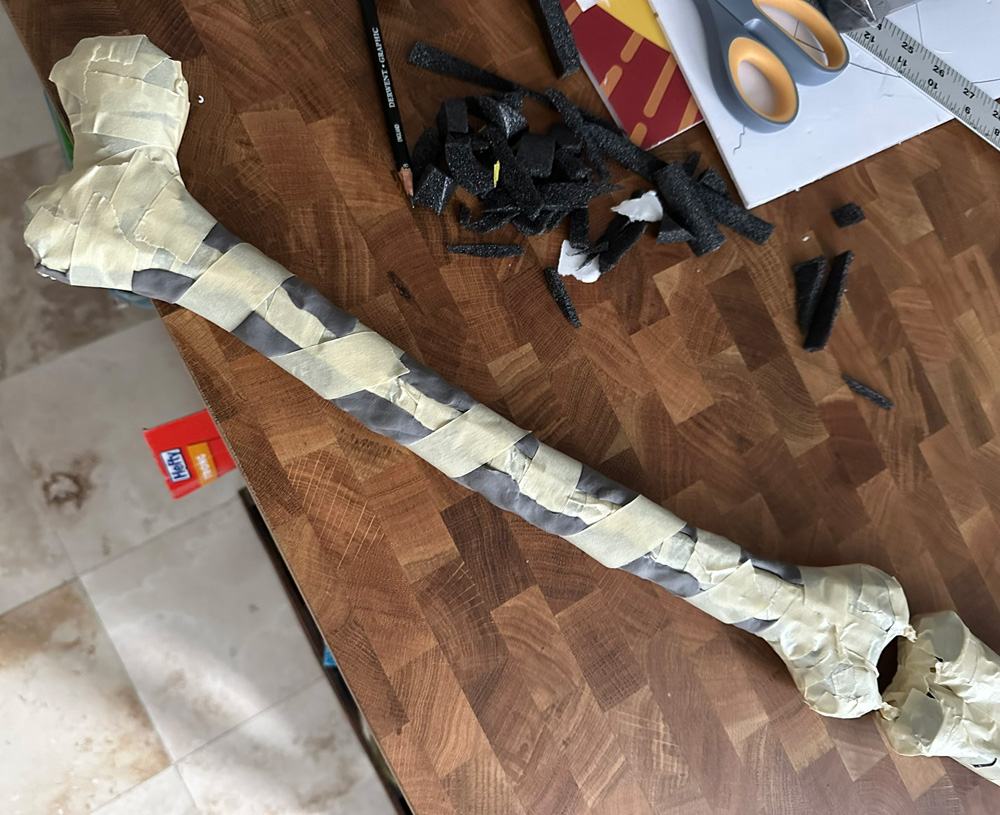 The upper arm bone with a long strip of foam clay pressed into the side to smooth it out.