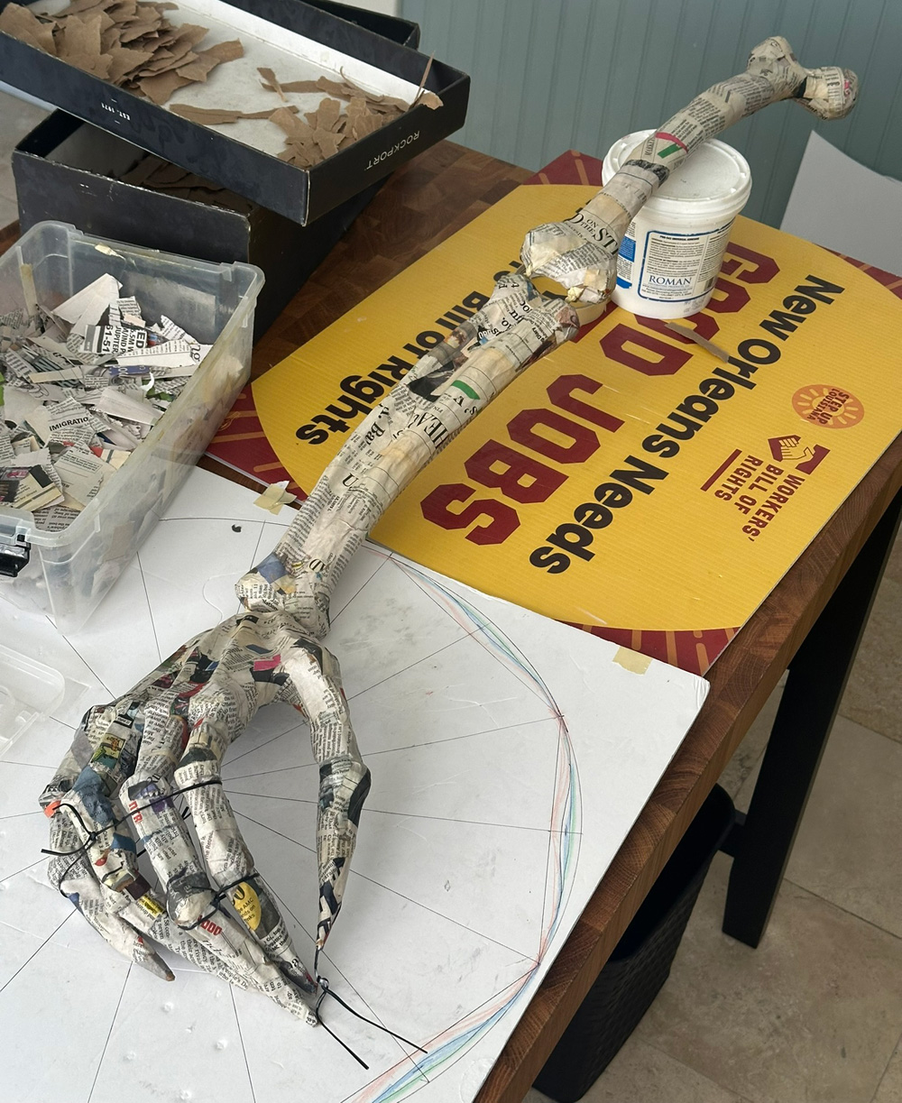 The whole arm assembled and covered in little strips of newspaper.