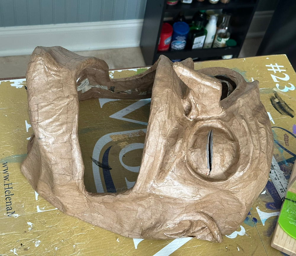 The witch face is now covered with brown paper mache.