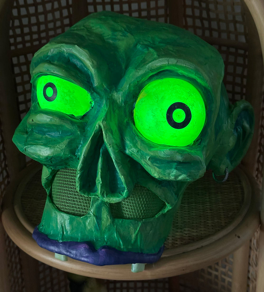 Green zombie mask with bulging light-green light-up eyes.
