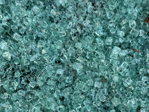 Tiny chunks of broken glass from a car window, looking blue-ish.